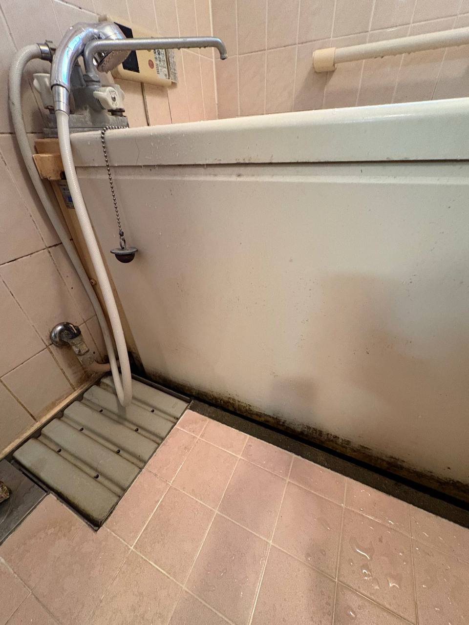 浴室クリーニング前の浴槽外側面と床の水垢汚れ