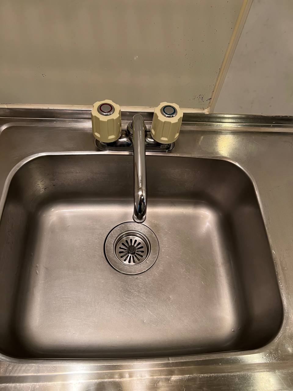 ステンレスシンクの水垢・くすみ汚れを除去し、排水口まわりまで明るい光沢に仕上げたシンク清掃後のafter写真｜おそうじフレッシュ