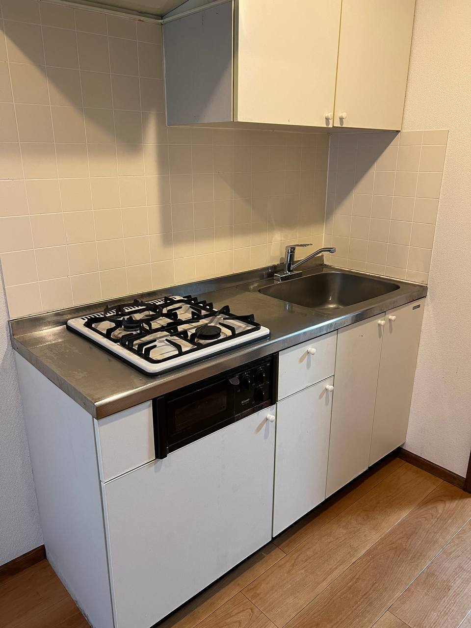 ガスコンロ・ステンレス天板・シンク・壁面タイル・収納扉までクリーニングし、油汚れや水垢を除去して全体を明るく仕上げたキッチン清掃後のafter写真｜おそうじフレッシュ