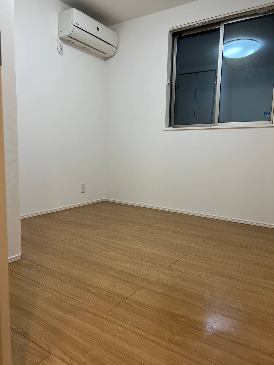 川崎市での空室クリーニング後、エアコンとフローリングを清掃し艶のある仕上がりになった洋室｜おそうじフレッシュ