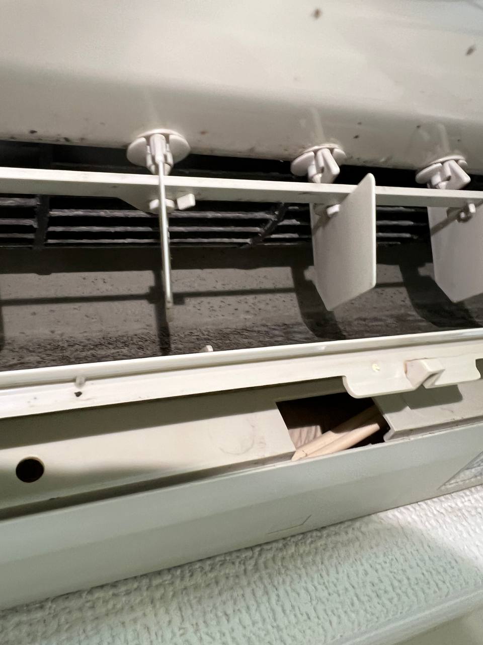 エアコン吹き出し口と送風ファンに蓄積したカビ・ホコリの汚れが見える分解前の状態｜おそうじフレッシュ